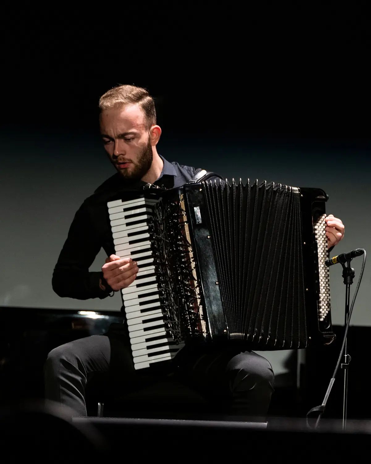 Sajdin Horozović im Konzert, dramatische Bühnenbeleuchtung auf dunkler Bühne