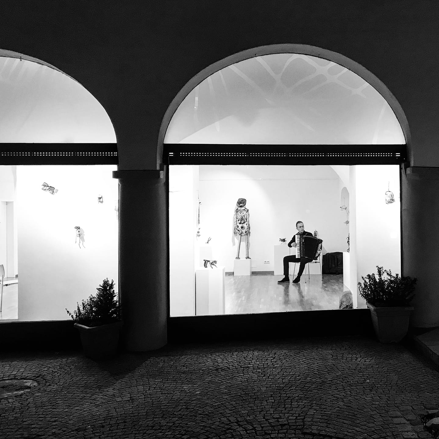 Sajdin Horozović spielt Akkordeon in einer Kunstgalerie, Schwarz-Weiß-Aufnahme
